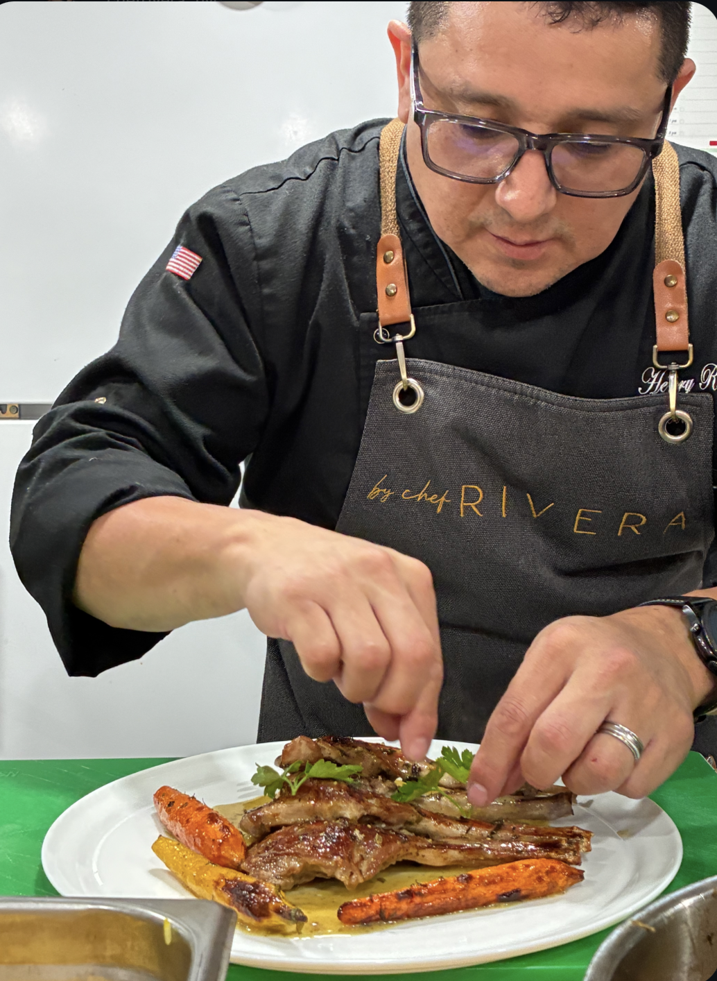 Chef Henry Rivera plating in executive chef coat and apron